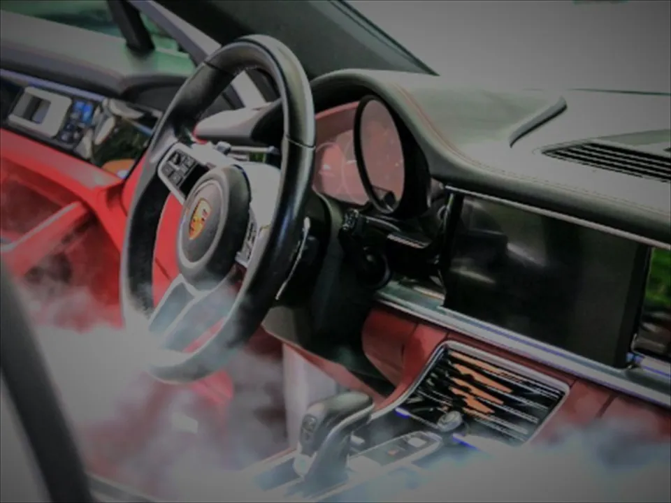 Porsche-interieur met rood leer tijdens het stomen, met waterdamp in de cabine